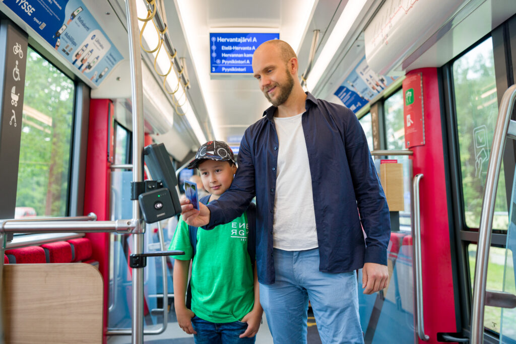 Mies ja poika Ratikassa kortinlukijan luona.